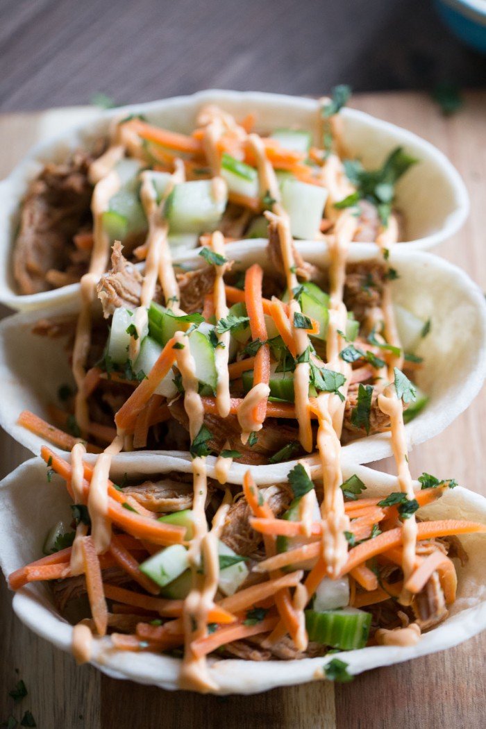 Bbq pulled pork with an asian flair! These taco boats start with pork that is slow cooked in an Asian inspired sauce then topped with cucumbers, carrots and Sriracha mayo! lemonsforlulu.com